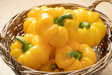 Basket with fresh picked yellow bell peppers close up