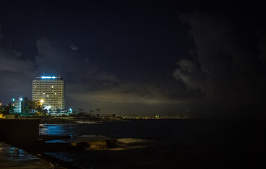 Naklejka premium sea City lights shore pier night