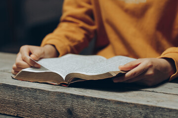 Christian woman wearing a yellow shirt reading and studying the bible at home or Sunday school.Sunday readings,spirituality, and religion Concept.