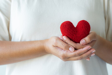 Adult hands holding a yarn red heart
