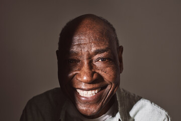 Portrait of smiling senior man against white background