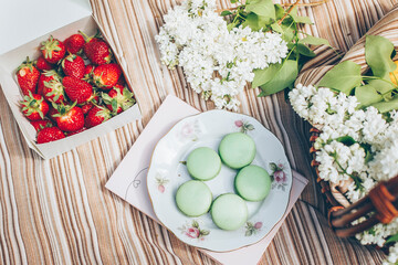 Spring picnic with berry and macaroons on plaid. Top view
