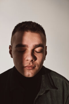 Young man with eyes closed over white background