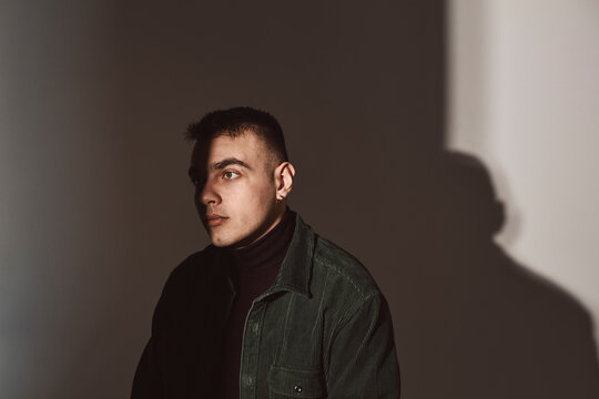 Contemplative man looking away against white background in studio