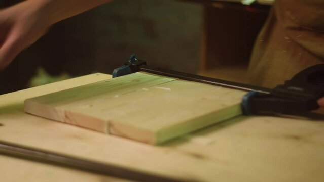 A mature carpenter makes works in his carpentry workshop, glues together wooden blanks