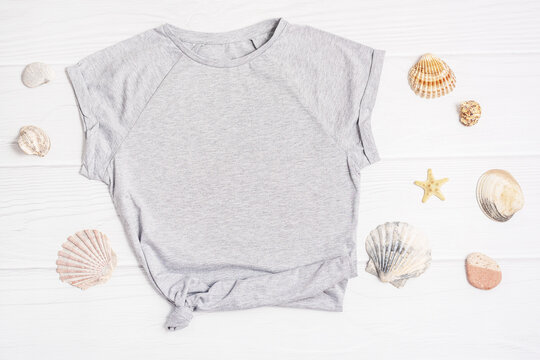 Gray T Shirt mockup flat lay Sea shells white wooden background. Summer vacation concept