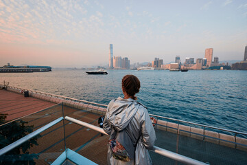 Fototapeta na wymiar Woman on Hong Kong harbour promenade enjoying the city view.