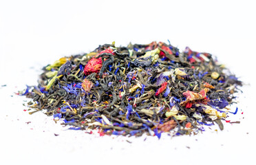 a scattering of dry green tea with the addition of cornflower flower, pomegranate flower, blue tea. A mixture of different types of tea on a white background