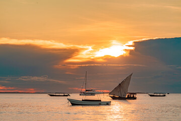 Fishing ship and boats in water of Indian ocean on a scenic sunset. Zanzibar, Tanzania - obrazy, fototapety, plakaty