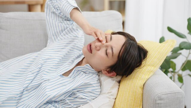 ソファーで昼寝をする若い女性
