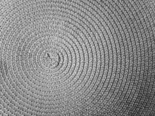 Close-up of a round modern wicker gray wicker tablecloth background. Circle carpet.