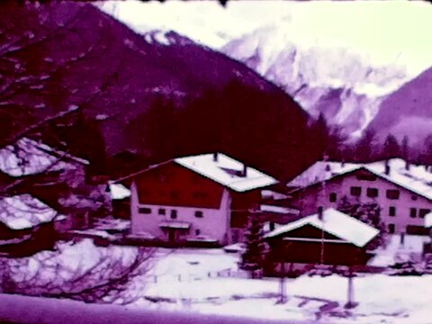 Swiss chalets in winter season during 1960s old grainy antique footage with scratches and grain