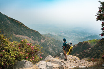 Hiker walking on top of a mountain and enjoying the view in India Mountains Himalayas Dharamshala...