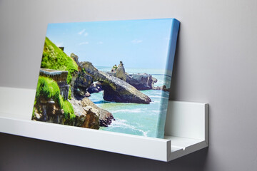 Canvas photo print with gallery wrapping and white shelf hanging on grey wall