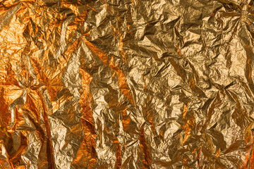 Crumpled golden foil abstract texture background