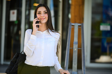 Portrait of a young woman talking on the phone on stairs outdoor