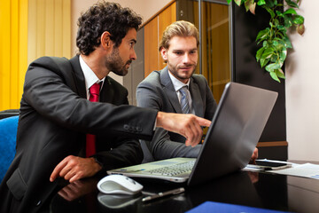 Two business partners working at a laptop in their office