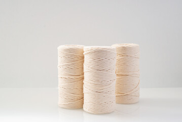 macrame threads wound bobbins of natural beige color