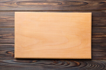 Top view of wooden cutting board on wooden background. Empty space for your design.=