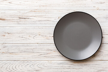 Top view of black plate on cement background. Empty space for your design.