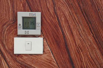  front view temperature screen and the power plug is turned off on brown wall background, object,...