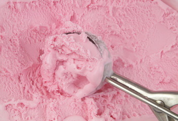 Strawberry ice cream and ice-cream scoop close up