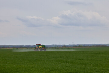 Fototapeta na wymiar a tractor that herbicides a wheat crop