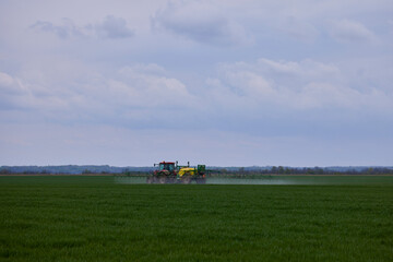Fototapeta na wymiar a tractor that herbicides a wheat crop