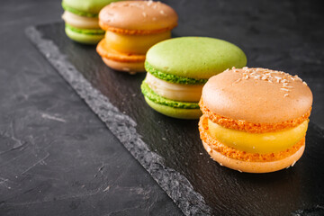 colored macaroons on a dark stone background