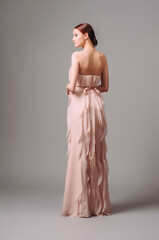 Light pink cocktail ruffled dress. Romantic backless evening look. Full-length elegant gown, rear view. Ginger young lady posing in studio. Bridesmaid's fashion.