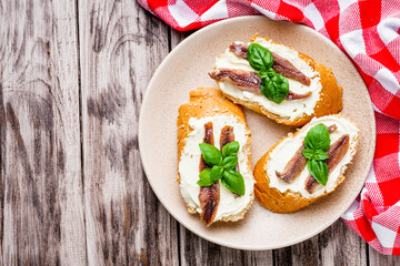 sandwich with anchovy fillet on a tray for serving on a wooden rustic background