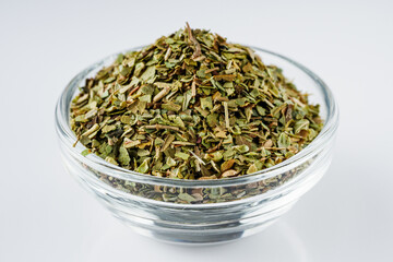 dried fragrant oregano marjoram on a white acrylic background