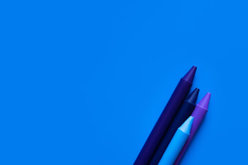 top view of gradient crayons on bright blue background.