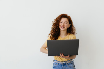 Portrait of happy young woman holding laptop on a white background