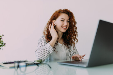 Portrait of curly young businesswoman in a headset holding the microphone, attentive customer...