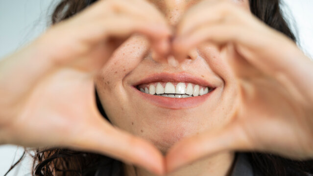 Woman smiling and making heart shape with her hands