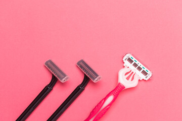 Female Skincare Concepts. Flat-Lay Image of Various Colorful Pink and Black  Disposable Razors Shavers Placed in One Directions On Pink Coral Background.