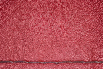 Red imitation leather with sewing seam. Texture, background