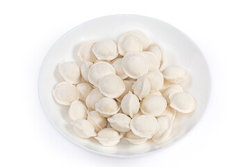 Uncooked frozen meat dumplings on dish on a white background