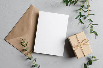 Greeting card mockup with gift, envelope and green eucalyptus twig