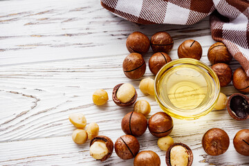 fresh macadamia nuts on a white wooden rustic background