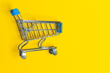 Empty Trolley Design Shopping or Sale Cart Placed Over Seamless Solid Yellow  Background With Space for Text