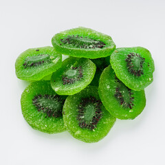 green dried kiwi on a white acrylic background