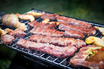 Making barbeque in nature. Barbecue with meat and fire for holidays. Tasty BBQ on picnic day.