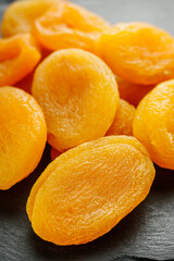 delicious dried apricots on a black wooden rustic background