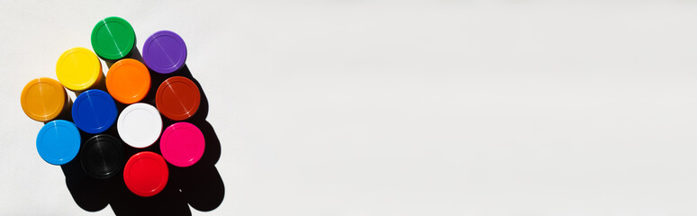 top view of jars with colorful paint on white, banner.