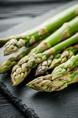 raw green asparagus on a black wooden rustic background