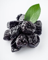 delicious dried prunes on a white acrylic background