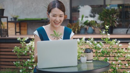 Asian beautiful lifestyle young woman talk selling small tree and cactus online by laptop computer...
