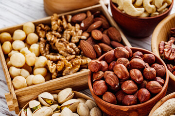 set of different nuts on a white wooden rustic background